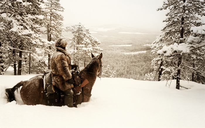 Cowboy in the snow with horse